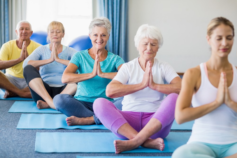 Group of seniors doing yoga with an instructor