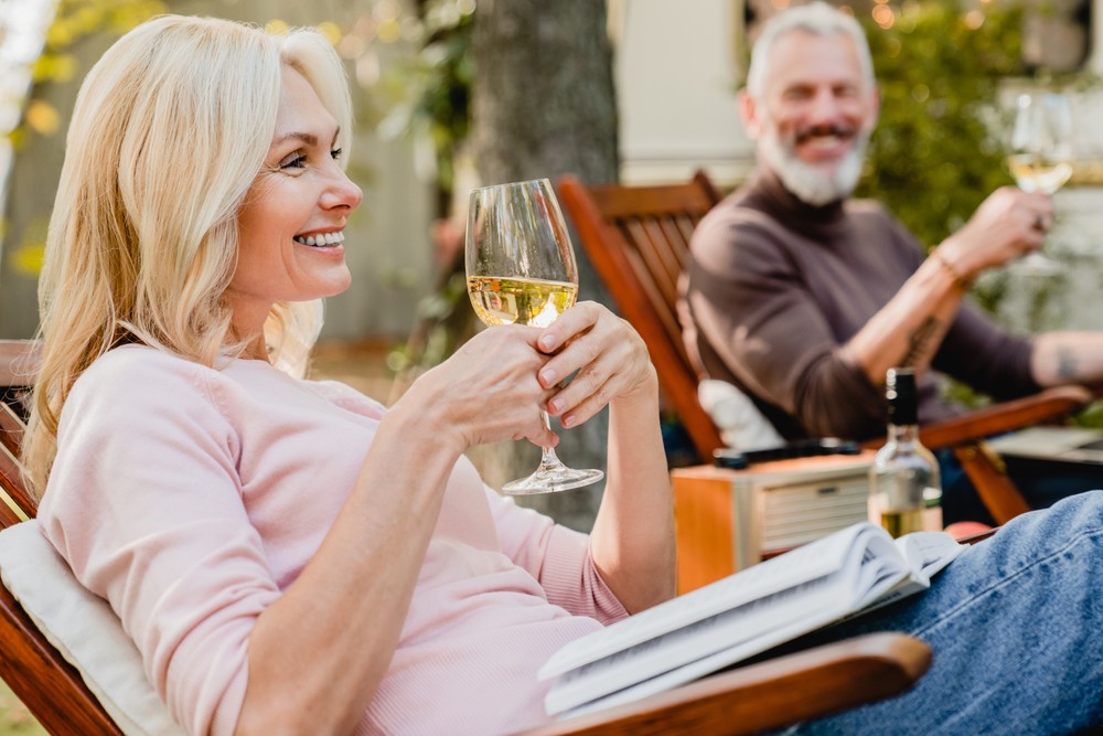 Senior couple relaxing in the garden with a glass of wine