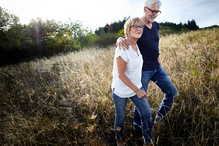 Senior couple walking through a field