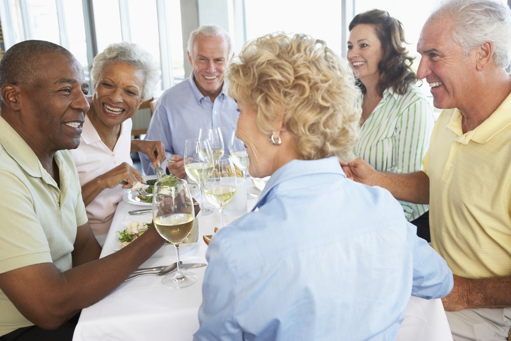 Seniors socializing while eating and drinking